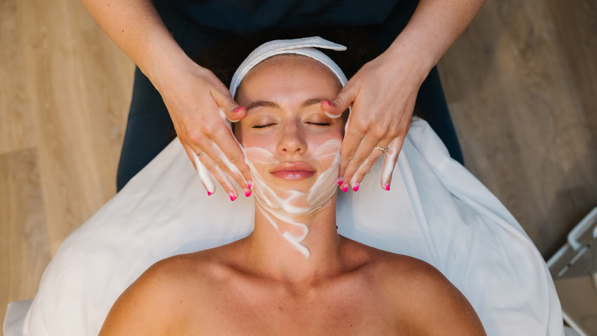 A woman laying down and relaxed during a facial.